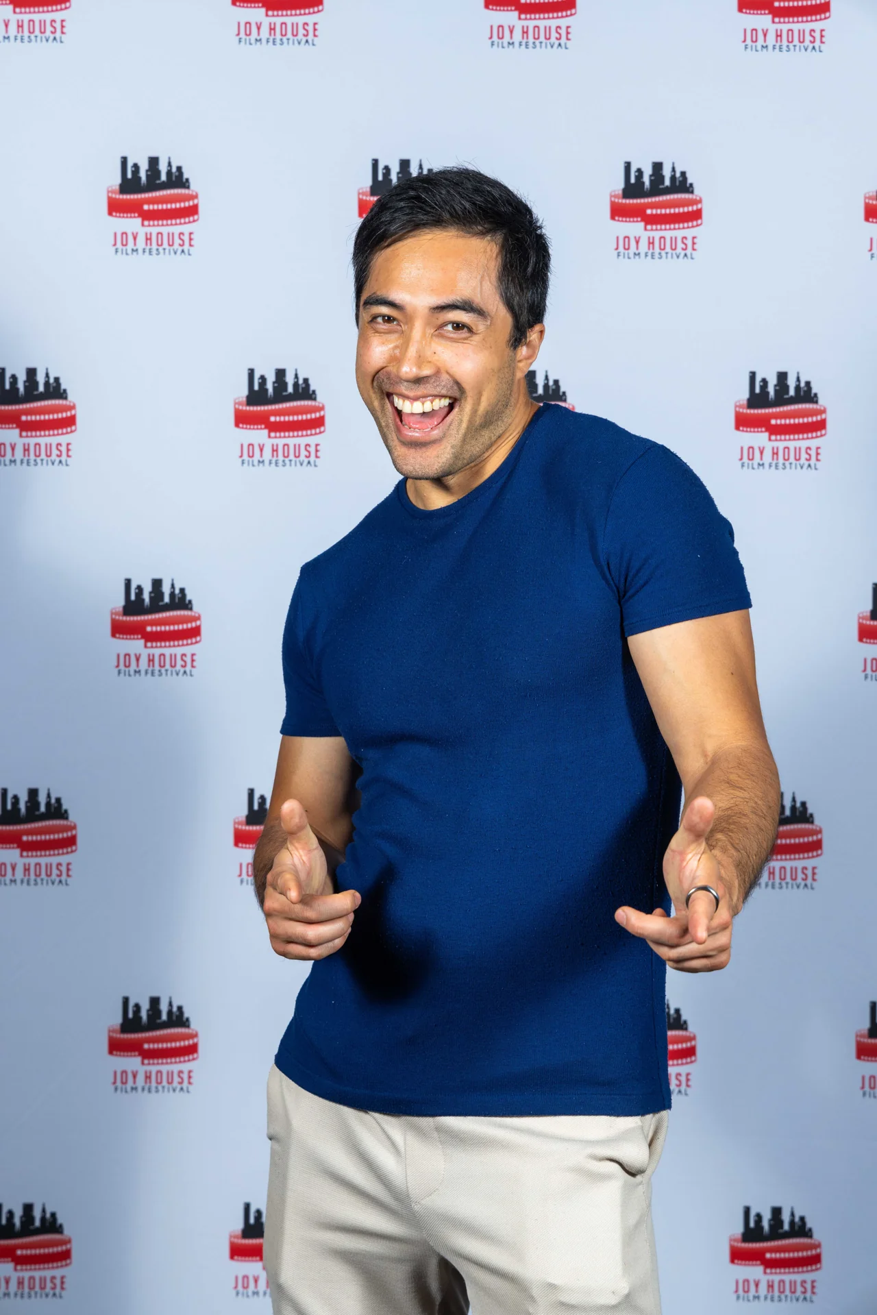 Damien Sato smiling at a media backdrop